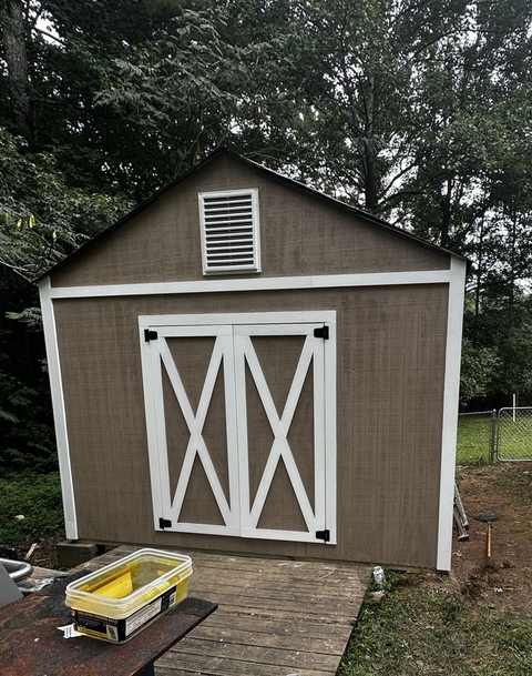 Rebuilt storage shed with new siding, trim, and roof