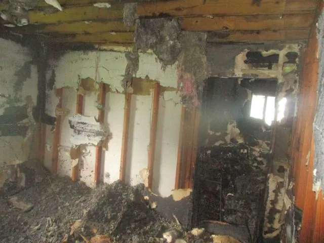 Living room before restoration, fire damage to walls and flooring
